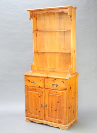 A Victorian style pine dresser, the raised back fitted 2 shelves, the base with 2 drawers above double cupboard 190cm h x 85cm w x 44cm d (some water damage to the top)