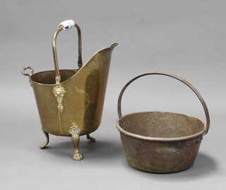 A brass helmet shaped coal scuttle on paw feet 47cm h x 29cm and a brass preserving pan with iron handle 17cm h x 37cm w 