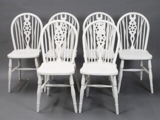 A set of 6 white painted stick and wheel back dining chairs