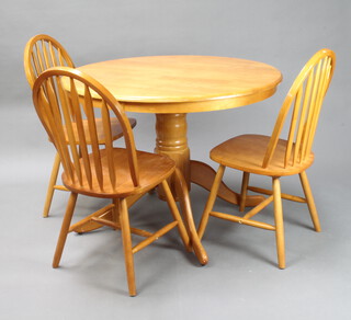 A beech framed circular pedestal dining table on a pillar and tripod base together with 3 hoop back dining chairs 