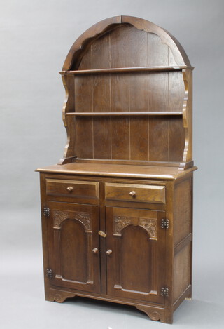 An oak dresser the arch raised back fitted 2 shelves, base fitted 2 drawers above double cupboard 90cm h x 43cm w  