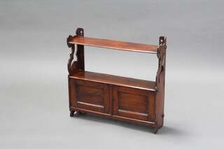 A Victorian mahogany hanging shelf with pierced panels to the sides the base enclosed by panelled doors 53cm x 54cm x 12cm (missing 2 roundels to the side and split to 1 side) 