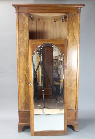 An Edwardian inlaid mahogany wardrobe with moulded cornice enclosed by arched bevelled plate mirrored door, base fitted a drawer on bracket feet 211cm h x 112cm w x 58cm d 