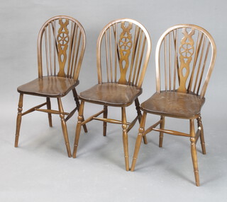 A set of 4 beech framed stick and wheel back dining chairs  