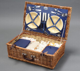 An Optima wicker picnic hamper containing glasses, flasks, plates, knives and forks
