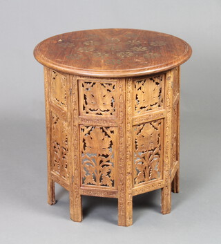 A circular Eastern inlaid brass occasional table raised on a pierced hardwood folding stand 54cm h x 53cm w 