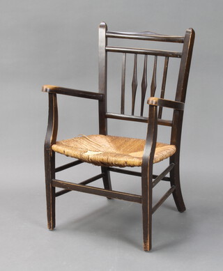 An Art Nouveau William Morris style beech stick and rail back open armchair with woven cane seat (cane work is damaged)