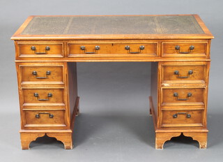 A Georgian style yew kneehole pedestal desk with green inset writing surface above 1 long and 8 short drawers, on bracket feet 76cm h x 122cm w x 60cm d (contact marks in places) 