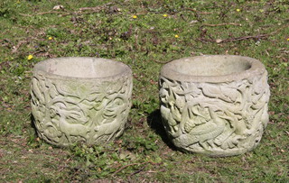 A pair of circular well weathered reconstituted stone garden urns of cylindrical form decorated animals 23cm h x 29cm 
