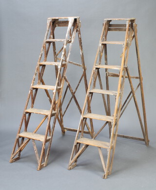 Two pairs of 1930's wooden 5 tread platform steps (to be used for decorative purposes only) 153cm h x 42cm when closed x 117cm when open  (1 pair has damaged struts) 