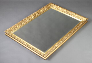 A rectangular bevelled plate wall mirror contained in a decorative gilt frame 104cm x 74cm 