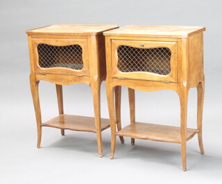 A pair of French style rectangular walnut bedside cabinets with grilled panelled doors raised on cabriole supports with undertier 72cm h x 48cm w x 30cm d (some beading missing to the top and both cabinets have sun bleaching, water marks and 1 knob is missing) 