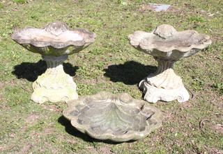 A pair of reconstituted stone scallop shaped bird baths, raised on circular pedestals 39cm h x 49cm w x 47cm d and 1 other scallop shaped bird bath (no pedestal) 
