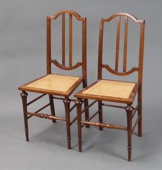 A pair of Edwardian mahogany stick and rail back bedroom chairs with woven cane seats 
