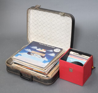 A collection of 1970's LP album records contained in a fibre suitcase together with a red case containing a small collection of 45rpm single records 