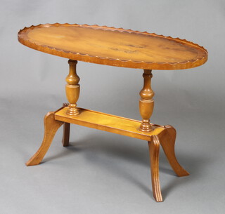An oval Georgian style yew 2 tier occasional table raised on outswept supports 53cm h x 76cm w x 42cm d (some marks to the top) 