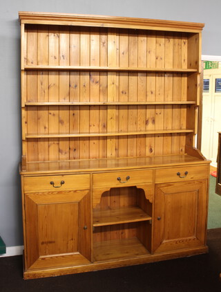 A Victorian style country house pine dresser with moulded cornice and 3 shelves, the base fitted 3 drawers above recess and cupboards, raised on a platform base 233cm h x 182cm w x 43cm d (water marks to the top) 