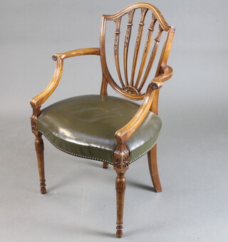 A Hepplewhite style mahogany shield back carver chair with over stuffed seat, raised on turned supports 