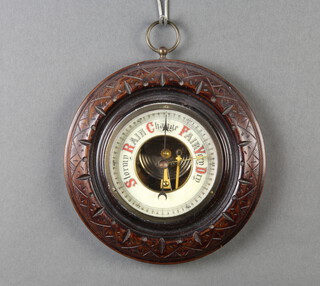 An Edwardian aneroid barometer, the 9cm circular, enamelled dial contained in a carved circular mahogany case, 18cm x 3cm 