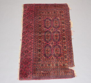 A red and blue ground Afghan rug with 6 octagons to the centre within multi row border 106cm x 78cm 