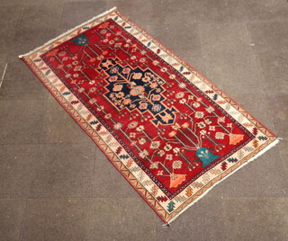 A North West Persian red and blue ground rug with central medallion with a 3 row border 230cm x 120cm 