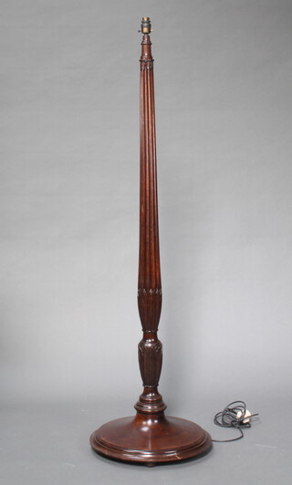 An Edwardian turned and reeded mahogany standard lamp raised on a circular base 155cm h x 46cm diam