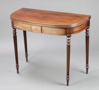 A 19th Century mahogany D shaped folding tea table raised on turned and reeded supports 73cm h x 91cm w x 45cm d 