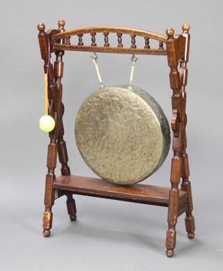 A Victorian oak and brass dinner gong, raised on a turned stand with bobbin turned decoration 94cm h x 63cm w x 26cm d 