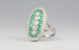 A platinum Art Deco style emerald and diamond up finger ring with 5 brilliant cut diamonds surrounded by emeralds surrounded by diamonds, emeralds approx. 1ct, diamonds approx. 1ct, 5.8 grams, size L 1/2