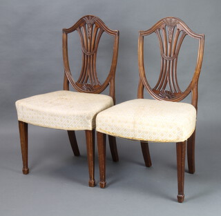 A pair of 19th Century Hepplewhite style shield back dining chairs with over stuffed seats, raised on square tapered supports, spade feet 