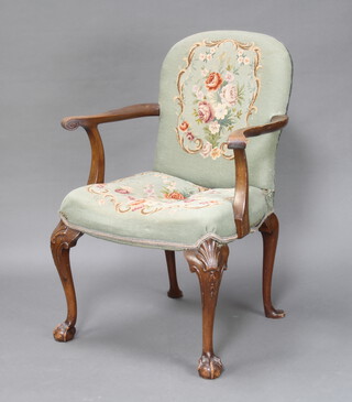 A Queen Anne style walnut open armchair, the seat and back upholstered in green floral Berlin woolwork tapestry, raised on cabriole, ball and claw supports 97cm h x 69cm w x 50cm d (inside seat measurement 42cm w x 50cm d)