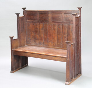 An Art Nouveau Liberty style panelled oak settle with raised back 124cm h x 123cm w x 52cm d 