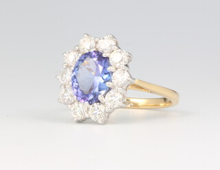 An 18ct yellow gold oval tanzanite and diamond cluster ring, the centre cut stone approx. 2.4ct surrounded by brilliant cut diamonds approx. 1.5ct, 5 grams, size P 1/2