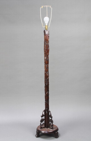 A 1930's Chinese carved hardwood standard lamp, raised on circular base, scroll feet 134cm h x 28cm diam. 