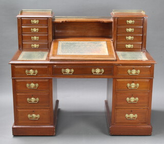 A Victorian mahogany Dickens desk with brass 3/4 gallery above a recess, the slope flanked by 8 short drawers, having an inset tooled leather writing surface above 1 dummy drawer and 8 short drawers 116cm h x 137cm w x 75cm d 