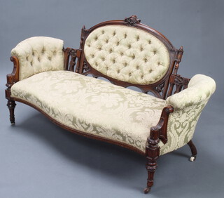 A Victorian carved walnut show frame sofa upholstered in green floral patterned material raised on turned and reeded supports 88cm h x 158cm w x (interior 121cm x 52cm) 