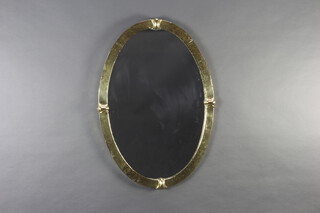 An Art Nouveau oval bevelled plate wall mirror contained in a planished brass frame 60cm h x 85cm w x 40cm d 