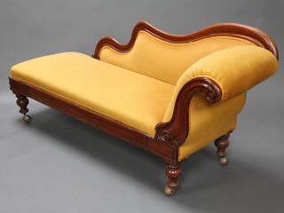 A Victorian mahogany show frame chaise longue upholstered in gold material, raised on turned supports with shepherd's castors 91cm h x 180cm l x 45cm d  