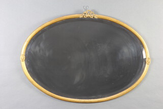 A Georgian style oval bevelled plate wall mirror contained in a gilt reeded frame surmounted by a garland 56cm h x 80cm w 