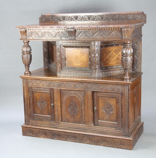 A Victorian carved oak 17th Century style court cupboard formed from old timber, the raised back with arcaded decoration, the top enclosed by an inlaid panelled door with cup and cover supports, the base (formed from an old coffer with evidence of hinge marks within) enclosed by panelled doors, raised on a platform base 145cm h x 136cm w x 60cm d 