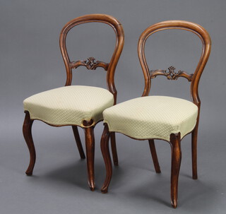A pair of Victorian bleached mahogany spoon back chairs with overstuffed seats and carved mid rails, fraised on French cabriole supports, 84cm h x 40cm w x 43cm d  