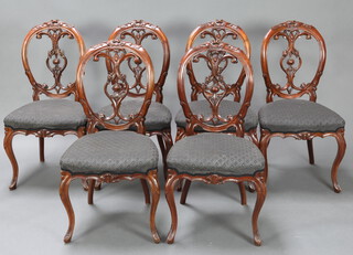 A set of 6 Victorian pierced and carved mahogany balloon back dining chairs with carved vase shaped slat backs and overstuffed seats, raised on French cabriole supports 93cm h x 47cm w x 39cm d