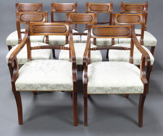 A set of 10 Regency mahogany bar back dining chairs with carved and turned mid rails and overstuffed seats, raised on sabre supports, comprising 2 carvers and 8 standard chairs, the bases impressed A8838, carvers 85cm h x 46cm w x 50cm d (inside chair measurement 45cm w x 44cmd), standard chair 83cm h x 37cm w x 43cm d   (inside 42cm w x 38cm d) 