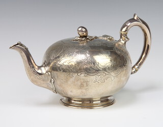 A Victorian silver melon shaped teapot with fruit finial and scroll handle, London 1856, 672 grams