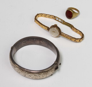 A lady's 9ct yellow gold Smiths wristwatch on a gilt bracelet, a silver bangle and a gilt ring 