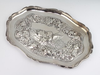 An Edwardian repousse silver serpentine dressing table tray decorated with masks and angels London 1905, maker William Comyns, 32cm, 298 grams