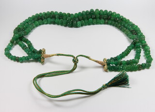 An emerald triple strand round carved bead necklace 60cm 