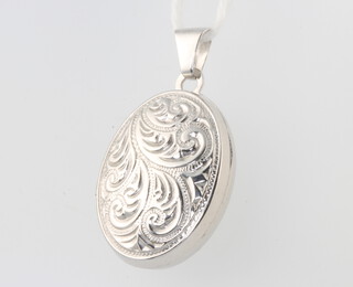 A 9ct white gold engraved oval locket 2.6 grams gross, 25mm