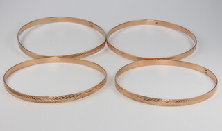 Four 14ct yellow gold engraved bangles, 35 grams