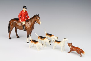 A Beswick figure "Huntsman" style 2, model no. 1501 brown gloss with red jacket, modelled by Arthur Greddington 21cm together with 4 hounds and a fox 